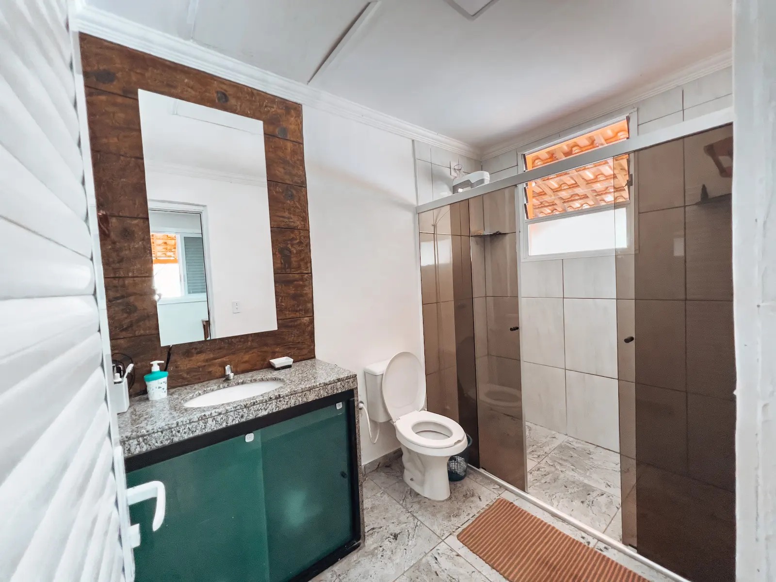Banheiro do Sítio Recanto dos Ipês — chuveiro, pia com granito e sanitário